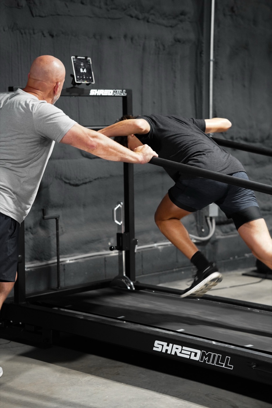 XPE coach spotting an athlete sprinting on the SHREDmill