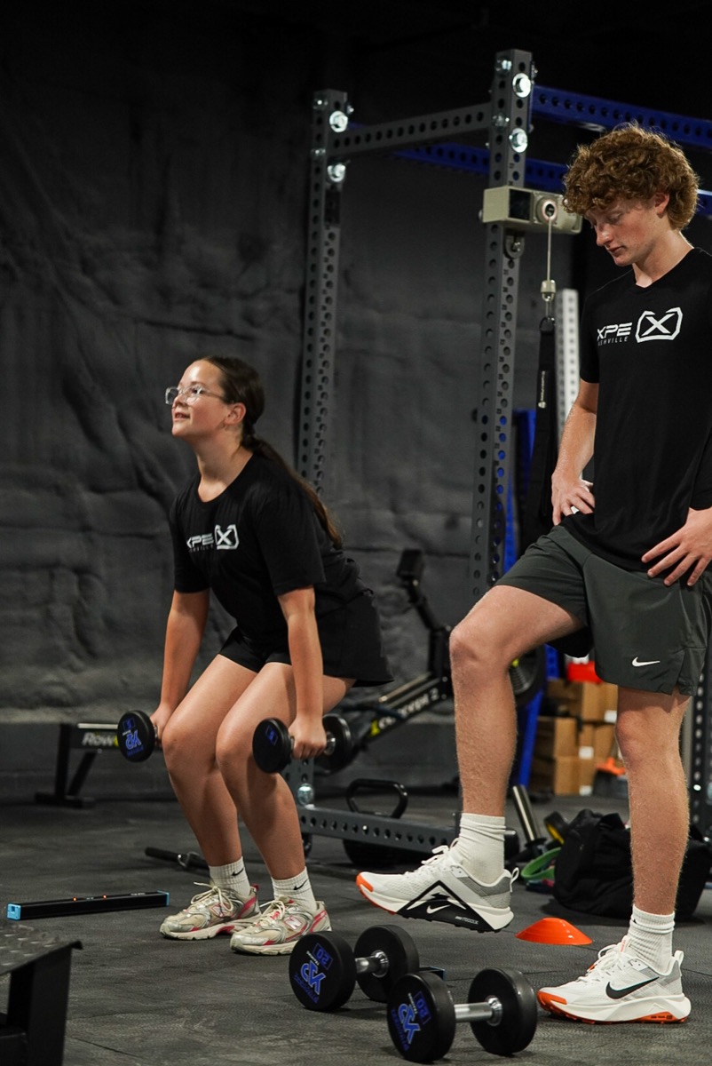 Athletes working through a dumbbell strength block