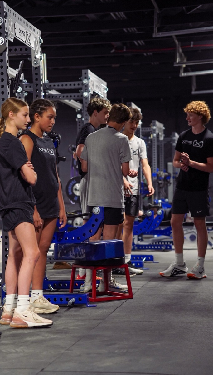 Athletes gathered at a training station on the XPE floor